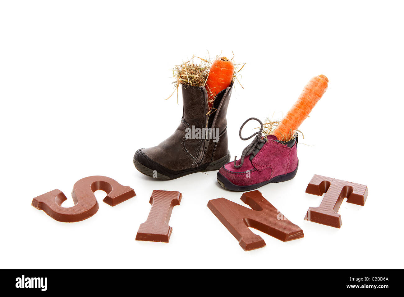 Sinterklaas, typisch holländischen Veranstaltung mit Schokolade Buchstaben und Karotte in Schuhen auf weißem Hintergrund Stockfoto