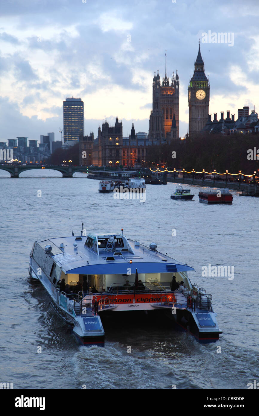 Thames Clipper-Passagier-Fähre verlässt Verkohlung Cross Pier in der Abenddämmerung. Houses of Parliament und Big Ben im Hintergrund Stockfoto