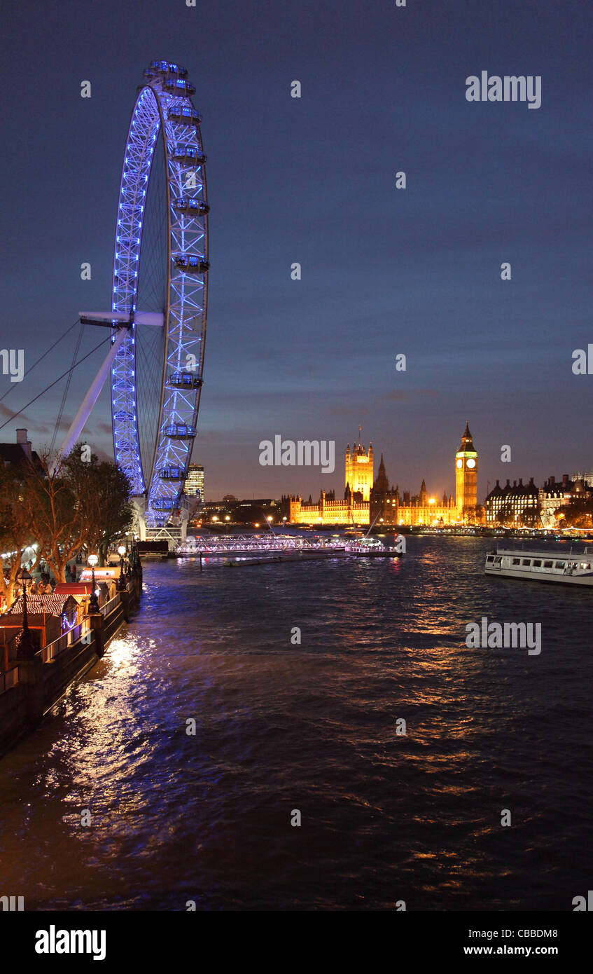 Das London Eye, Themse, Houses of Parliament und Big Ben aus Hungerford Bridge bei Nacht fotografiert. Stockfoto