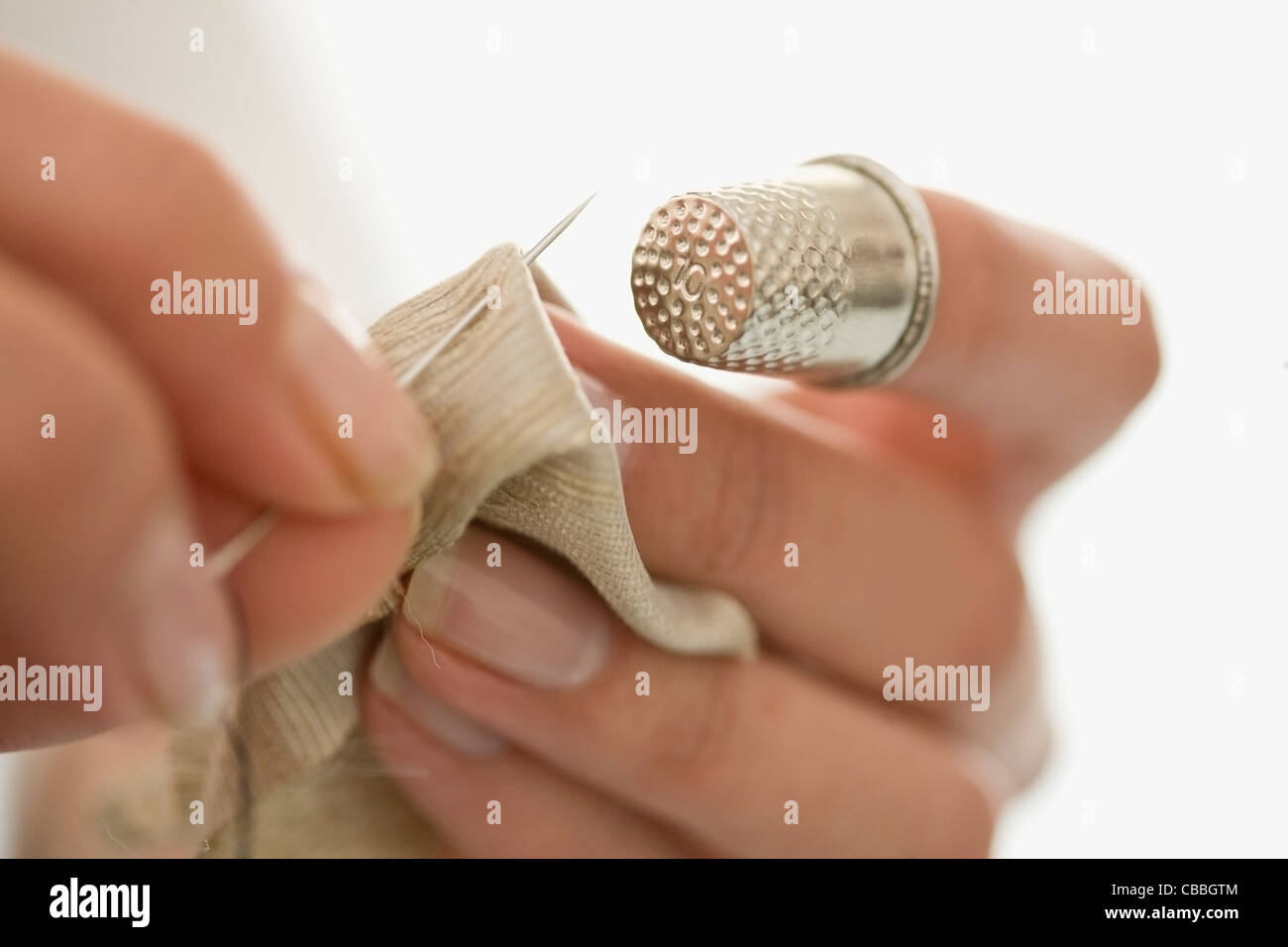 Nahaufnahme von Frau Nähen mit Fingerhut Stockfoto