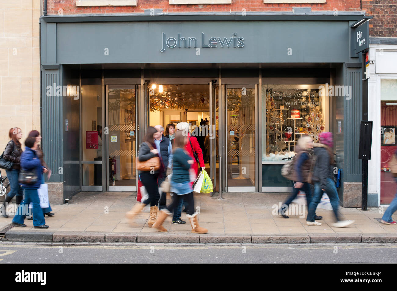 Käufer zu Fuß außerhalb John Lewis-Shop in Cambridge. Eine arbeitsreiche Zeit vor Weihnachten. Stockfoto