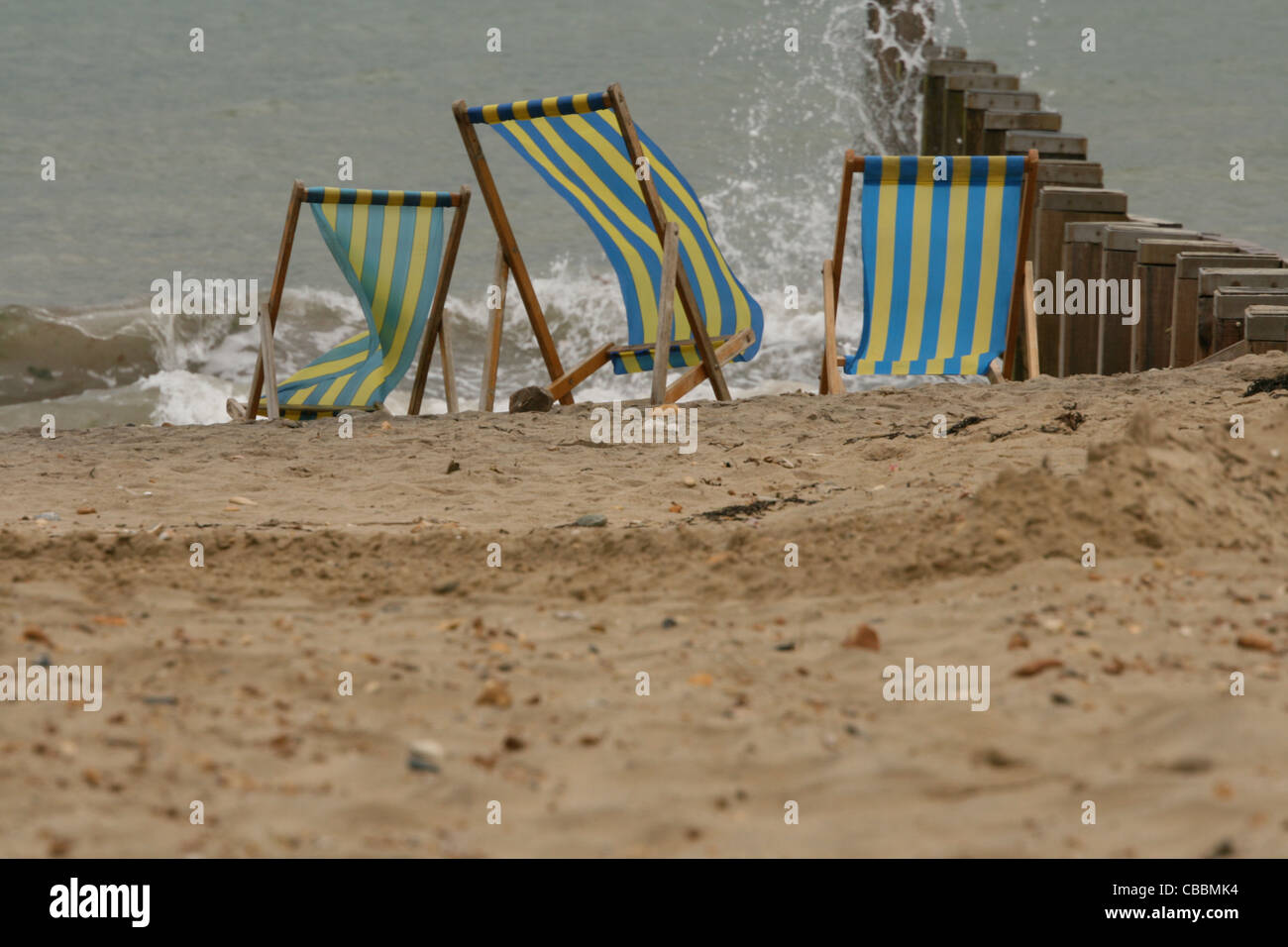 An einem windigen Strand Liegestühle Stockfoto