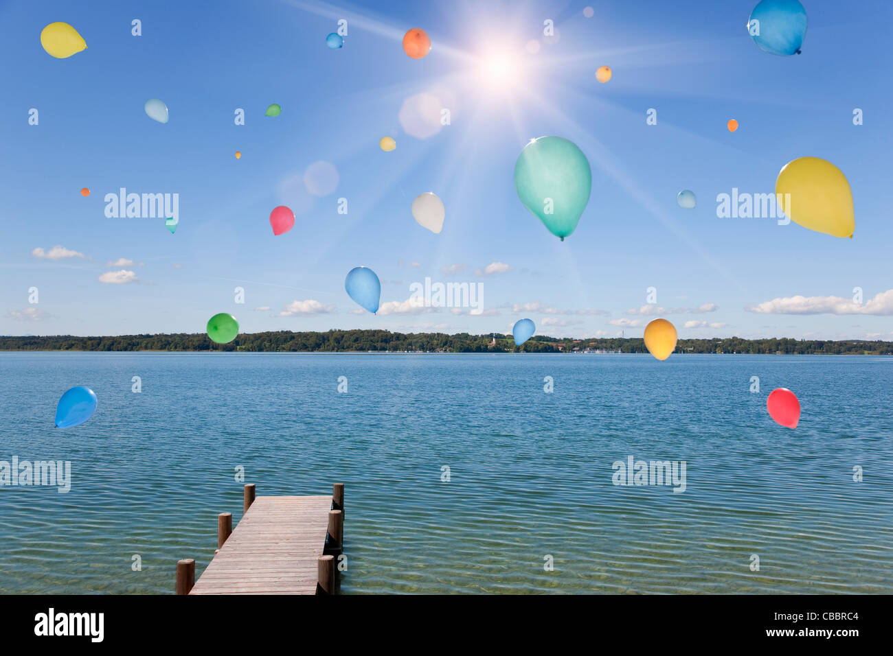 Luftballons schweben über noch See Stockfoto