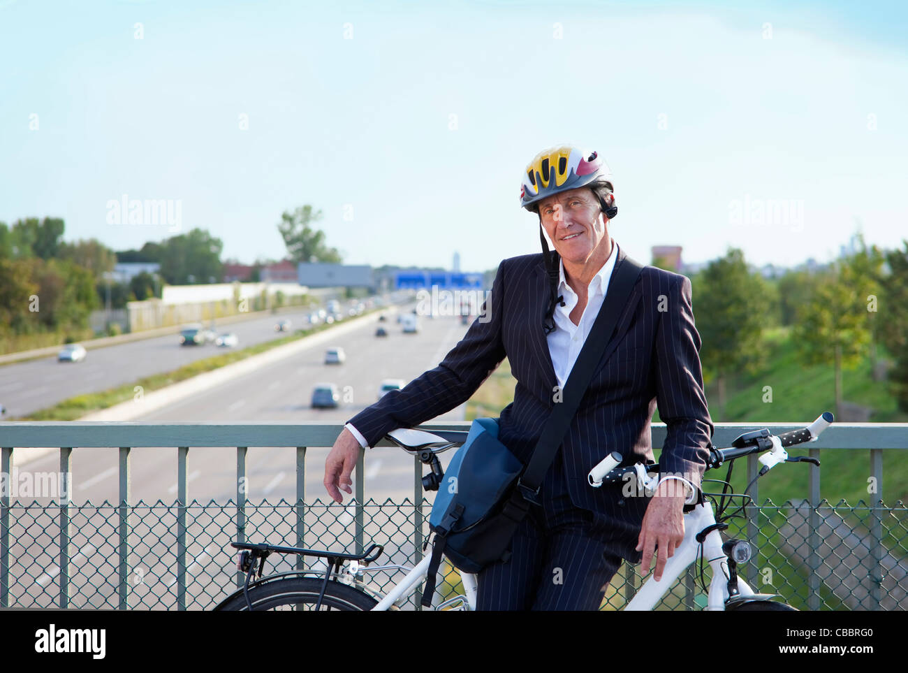 Geschäftsmann mit dem Fahrrad auf Brücke Stockfoto