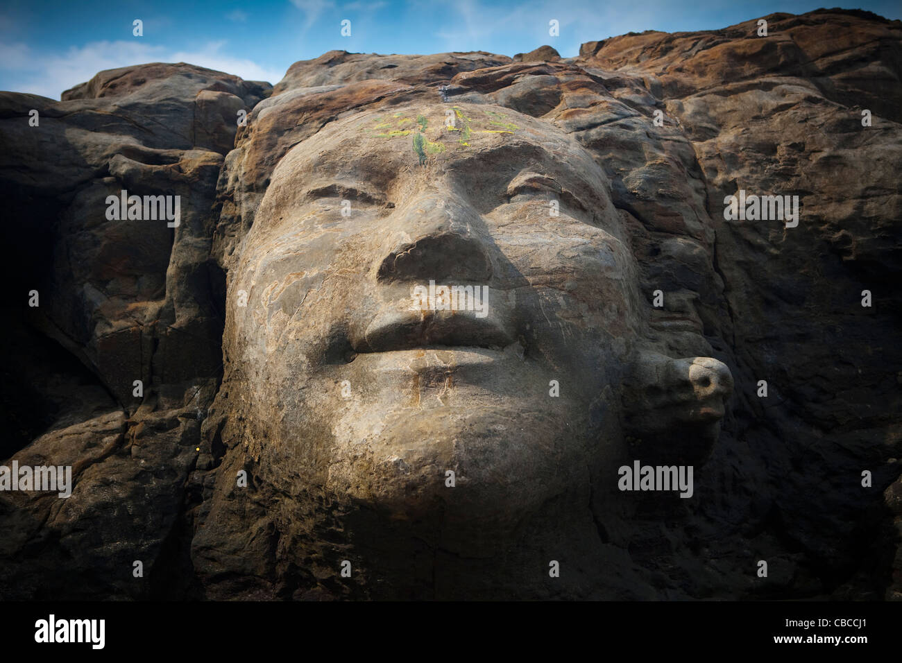 Das Gesicht des Shiva geschnitzt in Felsen auf kleinen Vagator Beach, North Goa, Indien Stockfoto