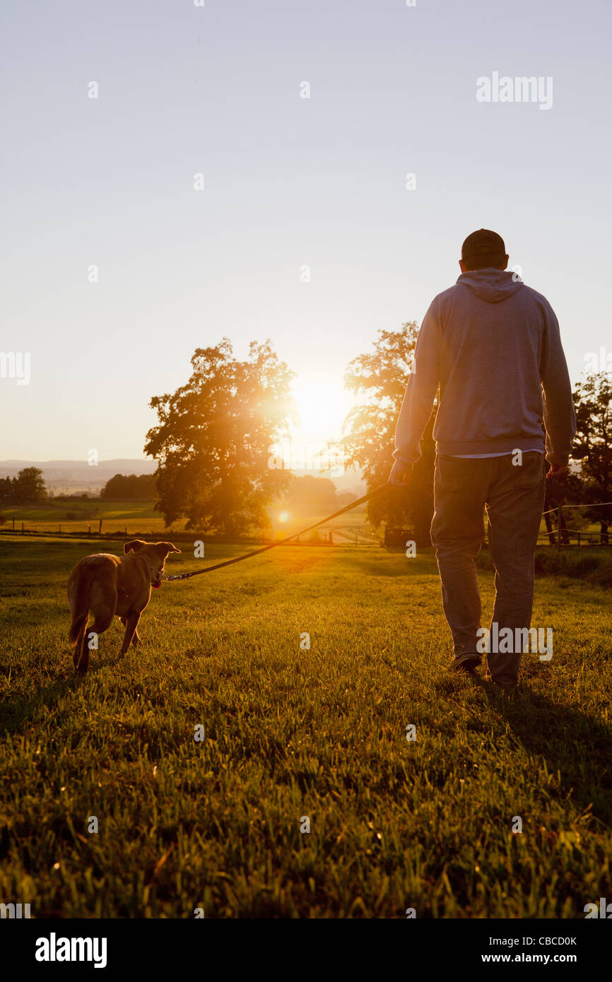 Mann zu Fuß Hund im ländlichen Bereich Stockfoto