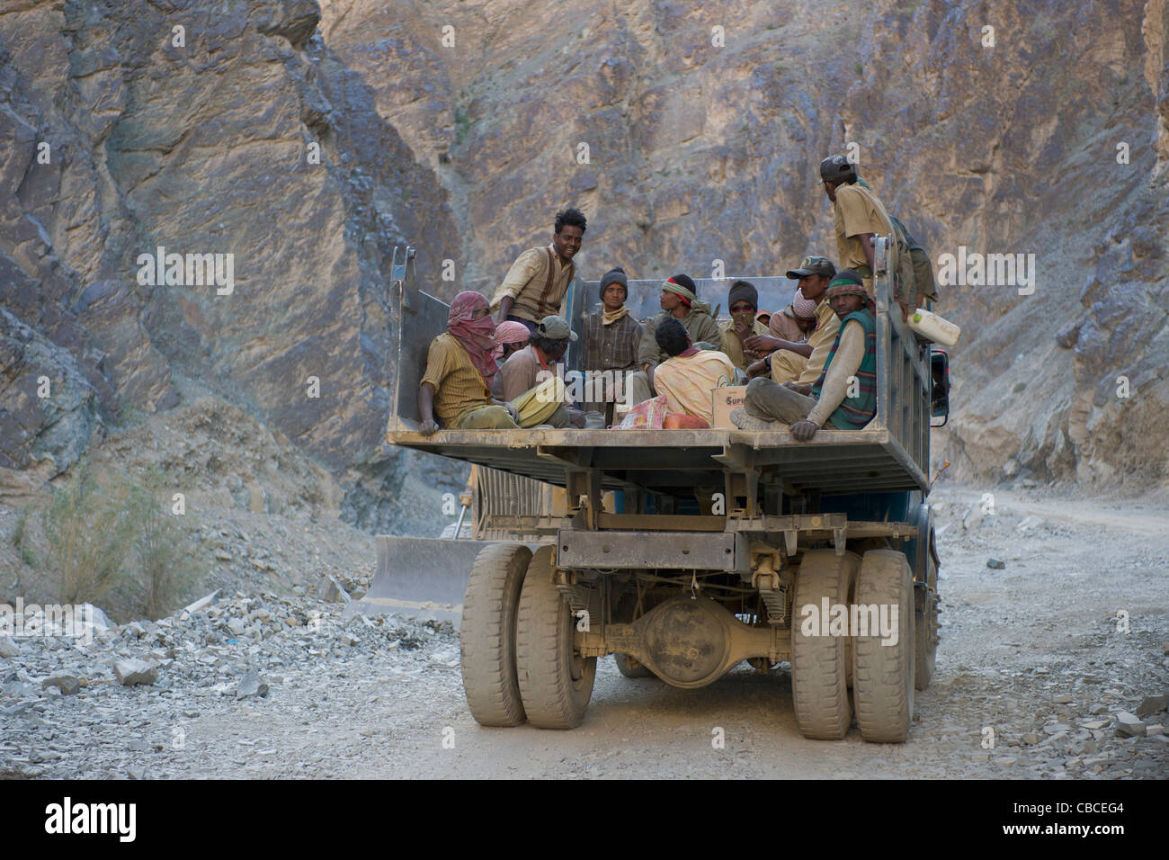 Arbeiter, Reiten auf dem Rücken eines Kipper-LKW auf der Autobahn Srinagar-Leh (Ladakh) Jammu & Kaschmir, Indien Stockfoto