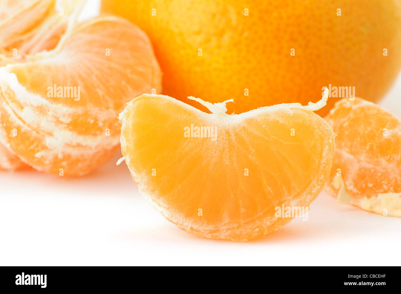Segmente und die ganze Mandarine. Ein Detailfoto von Obst auf weißem Hintergrund Stockfoto