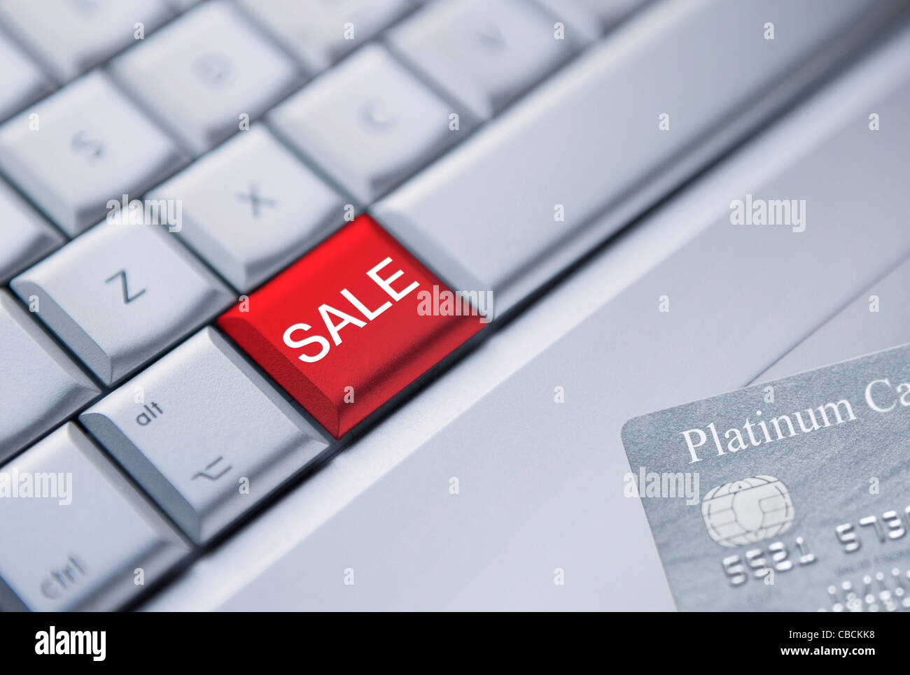 Detail eines Laptop Tastatur mit einem roten Schlüssel mit Verkauf und eine Kreditkarte in der unteren rechten Ecke gedruckt. Stockfoto