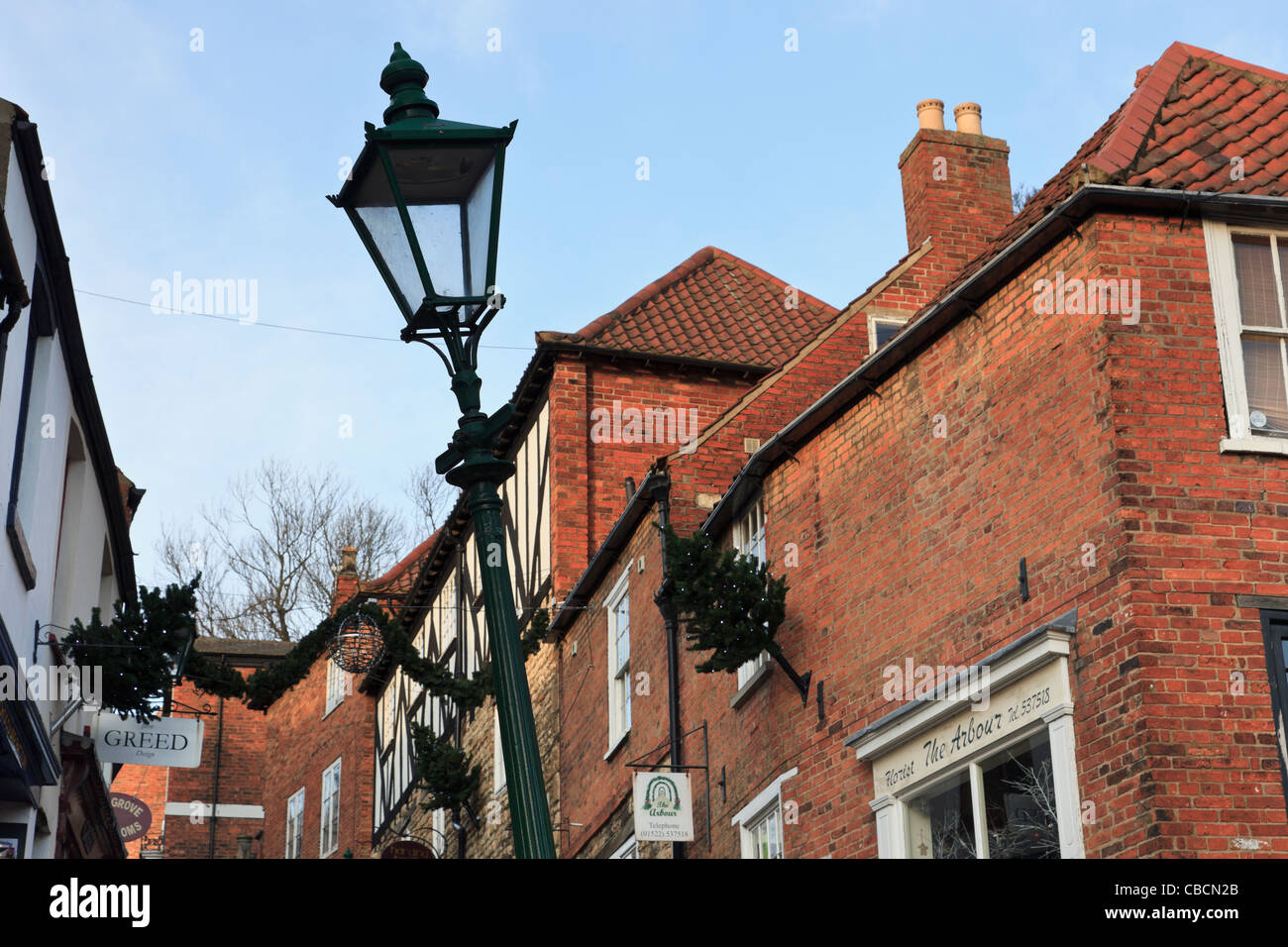Alten wackelig Laternenpfahl gelehnt in einer Straße im historischen Viertel der Stadt Lincoln Lincolnshire England UK Großbritannien Stockfoto
