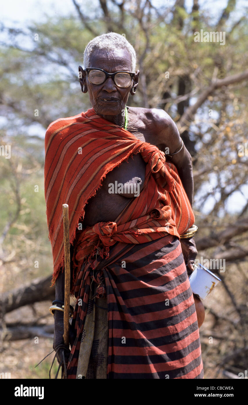 Alte Frau des Stammes Hadzabe ist sehbehindert und trägt eine dicke Brille Lake Eyasi-Tansania Stockfoto
