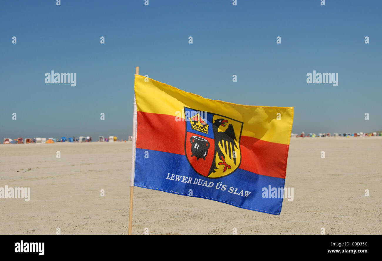 Die friesische Flagge wird gehisst auf dem sandigen Strand Nordstrand auf der nordfriesischen Insel Amrum in Schleswig-Holstein, Deutschland Stockfoto