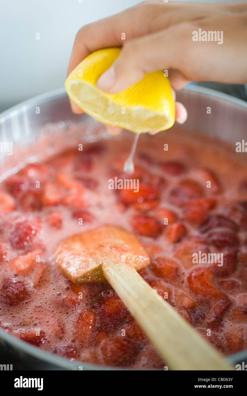 Machen Erdbeer Marmelade, frischer Zitronensaft hinzufügen Stockfoto