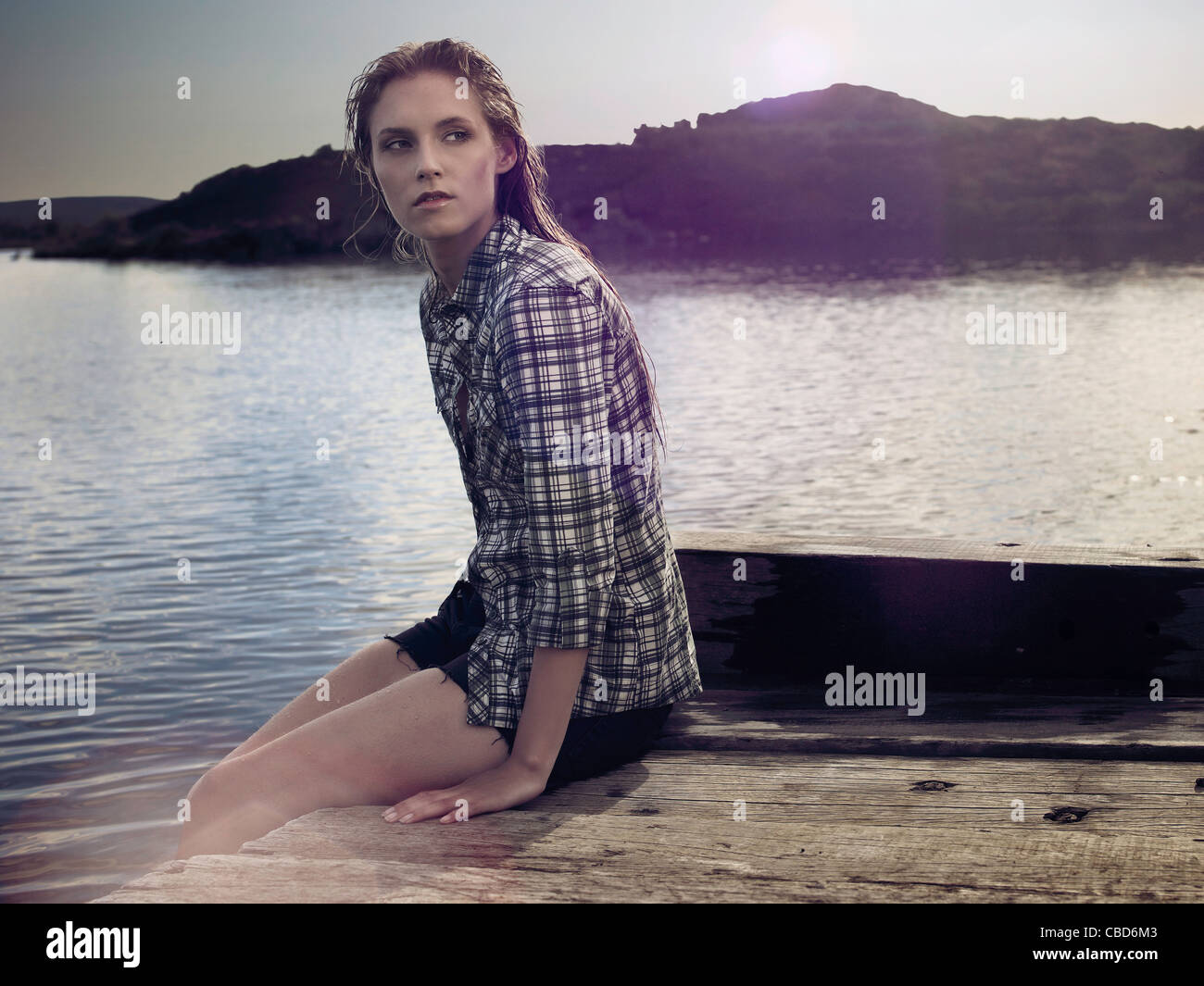 Frau sitzt auf dock-See Stockfoto