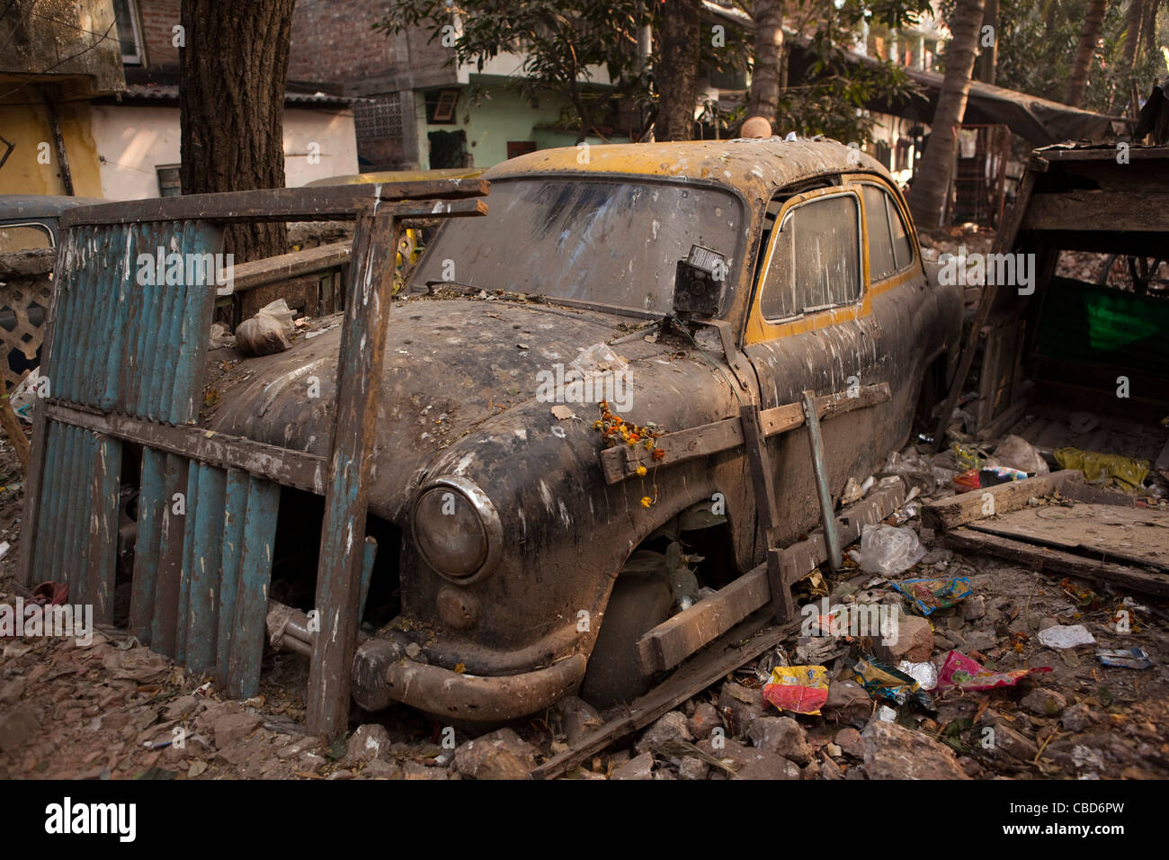 Rabindra Sarovar, verfallene Hindustan Ambassador Taxi in Müll begraben, Kolkata, Westbengalen, Indien Stockfoto