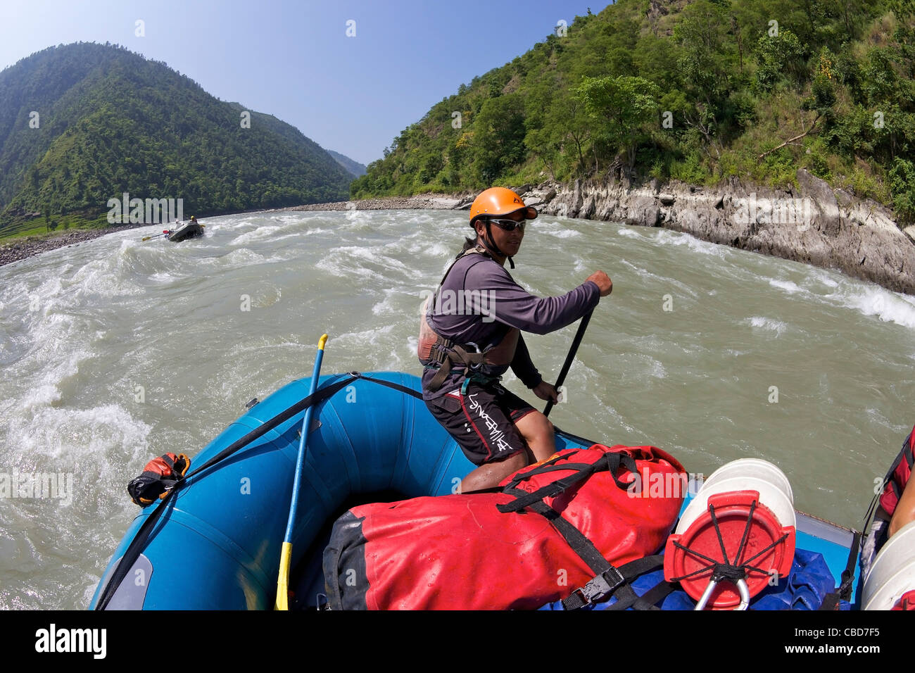 Nepali Guide Lenkung Boot auf Wildwasser-rafting-Tour auf Sun Kosi Fluß, Nepal, Asien Stockfoto