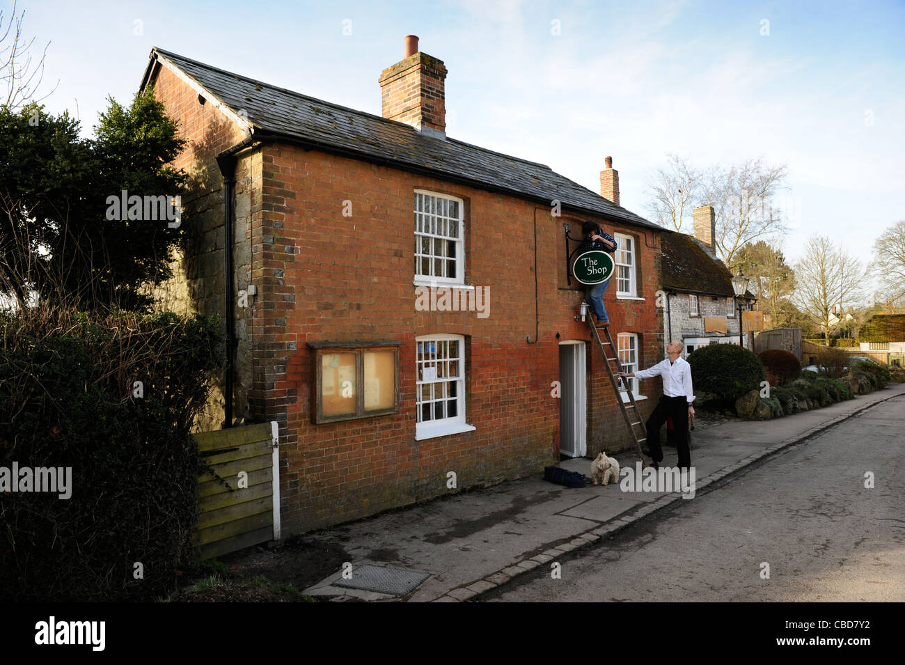 Schmied Keith Mahoney behebt Avebury Dorf Shop anmelden, bevor es am Sonntag Morgen Wiltshire UK (15. März 2009) öffnet Stockfoto