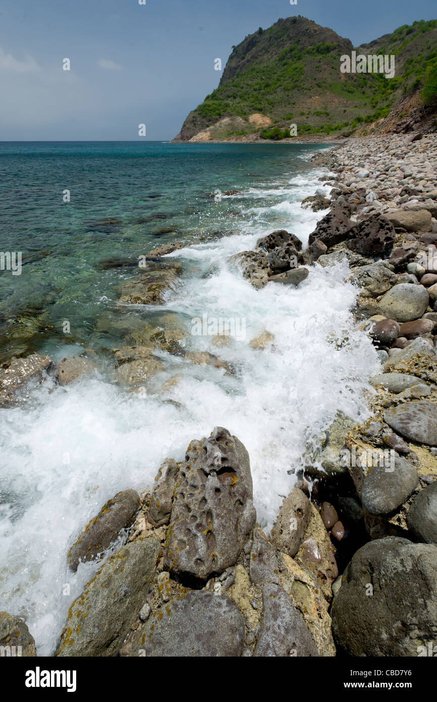 Wellen brechen auf Felsen und Kieselsteine am Ende des Rendezvous Bay, Montserrat Stockfoto