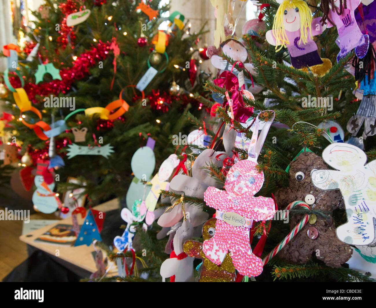 Eine Auswahl an abwechslungsreichen selbst gebastelten Christbaumschmuck, gemacht von Kindern, hängen eine der Filialen von mehreren Bäumen. Stockfoto