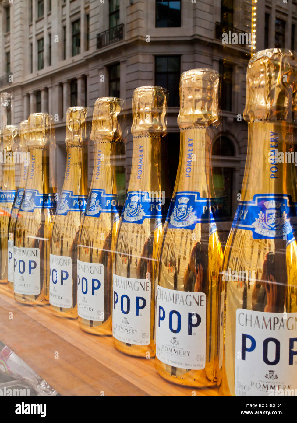 Gold farbigen Flaschen Champagner Pop zum Verkauf in das Fenster eines Ladens in der City of London financial district England UK Stockfoto