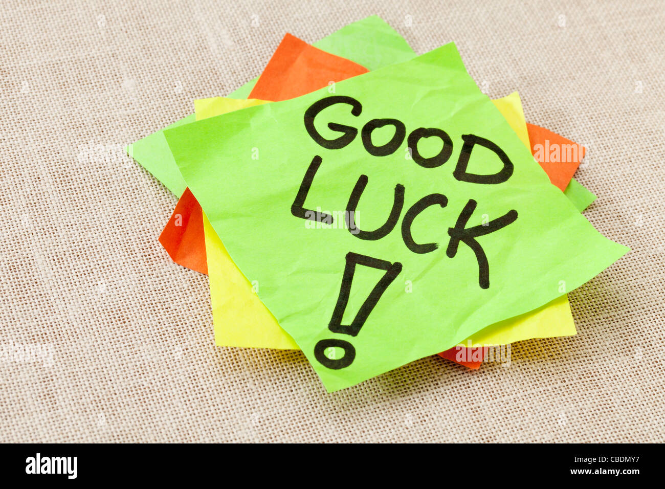 Viel Glück - schwarze Handschrift auf grüne Zettel gegen Leinwand Stockfoto