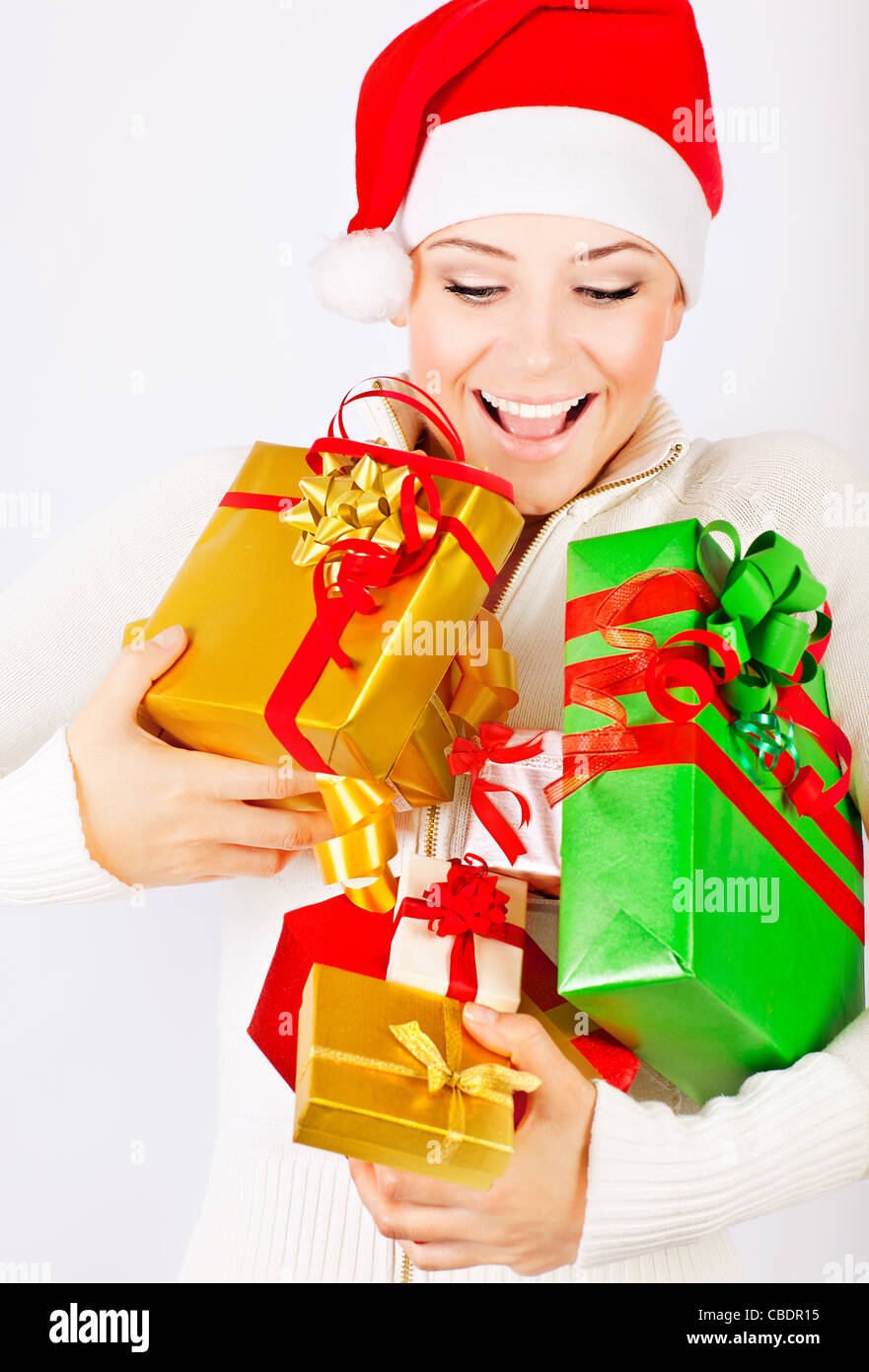 Fröhliches Santa Mädchen halten bunte Geschenke und präsente, Weihnachtszeit Spaß und Freude, Weihnachtsfeier der Winterferien Stockfoto