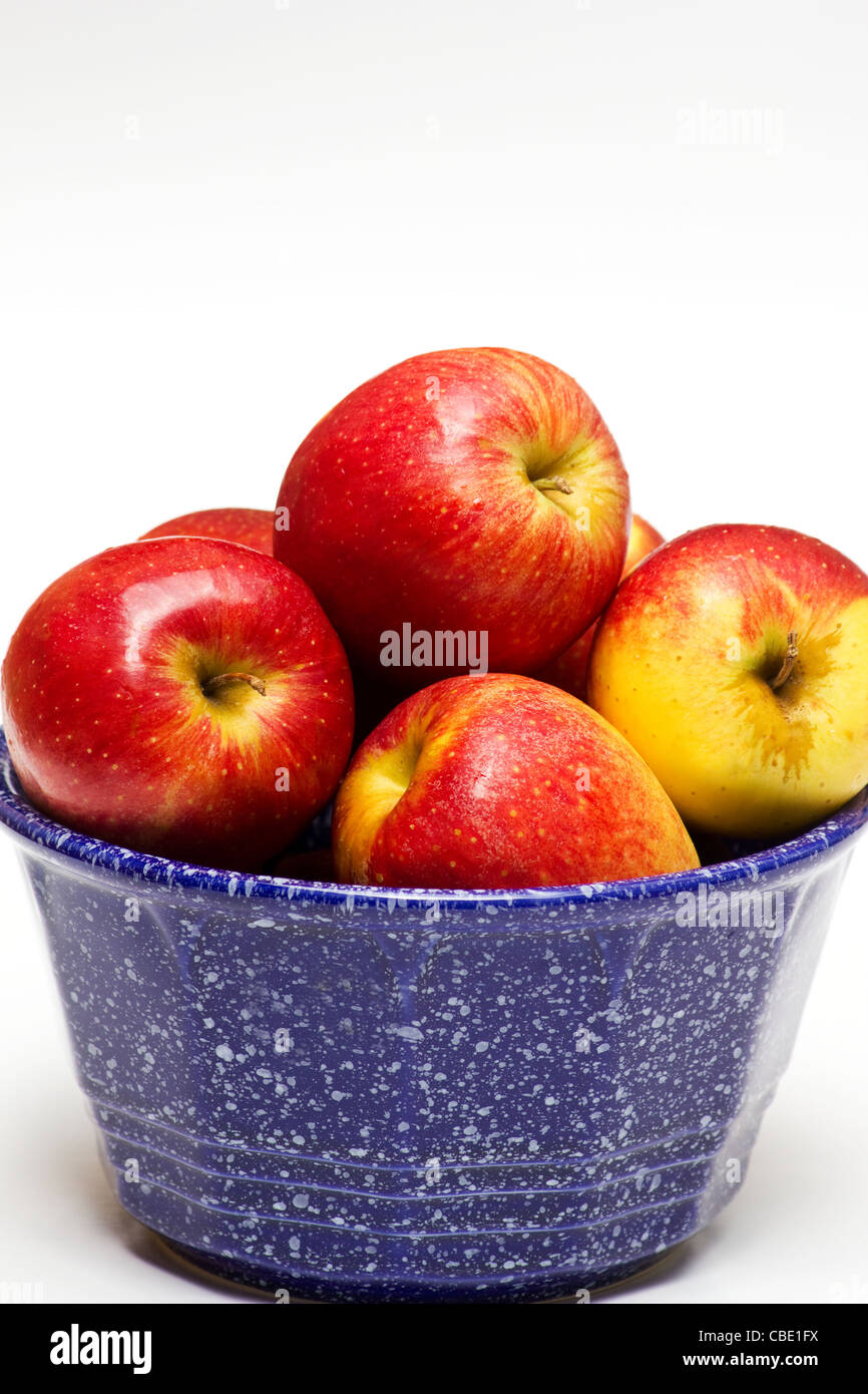 Frische rote Äpfel in eine blaue Keramikschale auf weißem Hintergrund Stockfoto