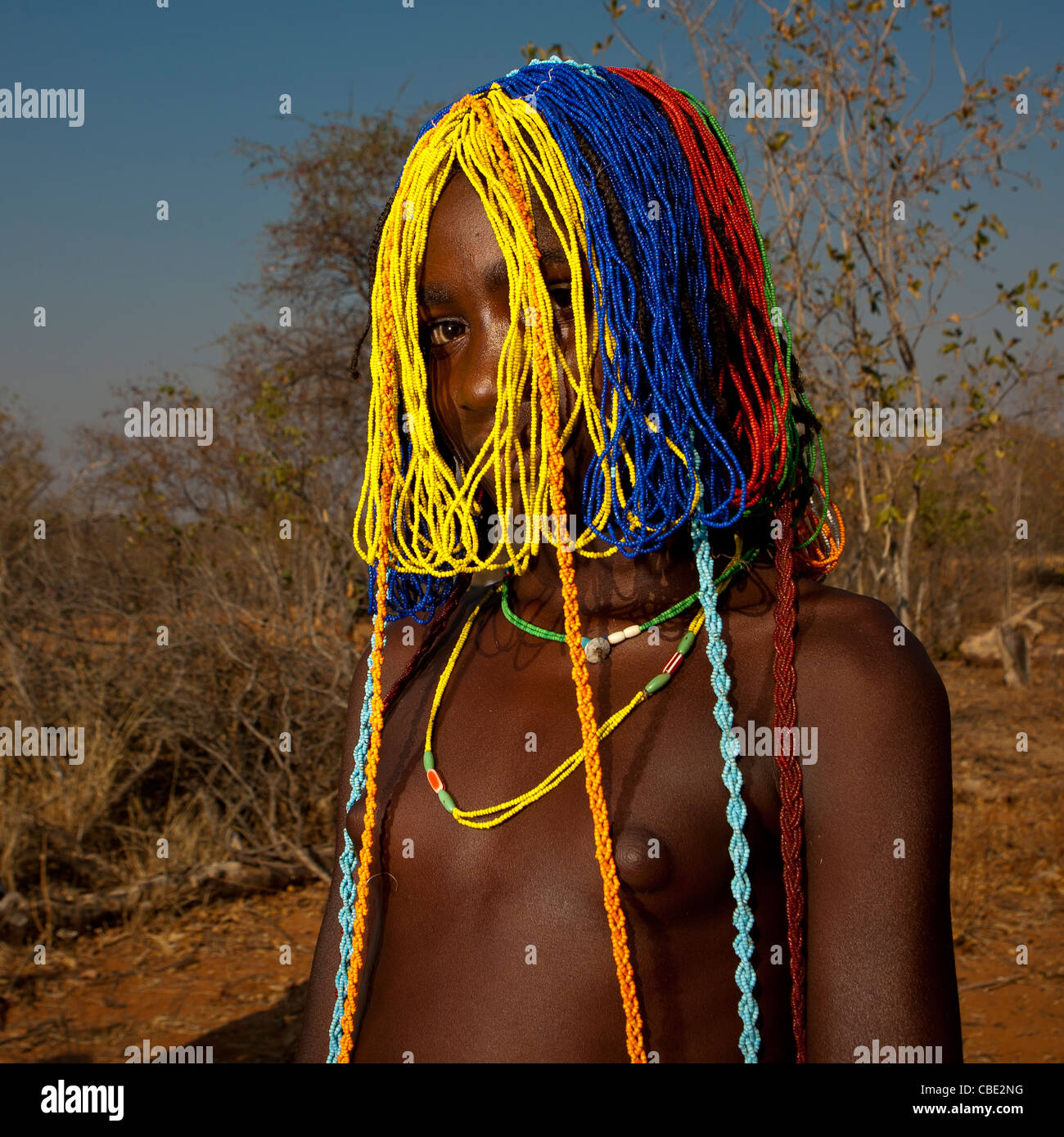 Mudimba Mädchen mit Perlen Perücke genannt Misses Ena, Dorf Combelo, Angola Stockfoto