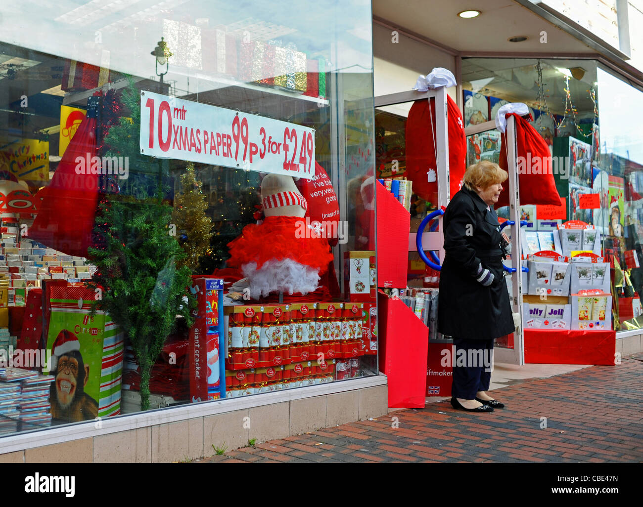 Frau außerhalb Weihnachten schneiden Preis Schnäppchen-Shop in Sittingbourne High Street Kent UK Stockfoto