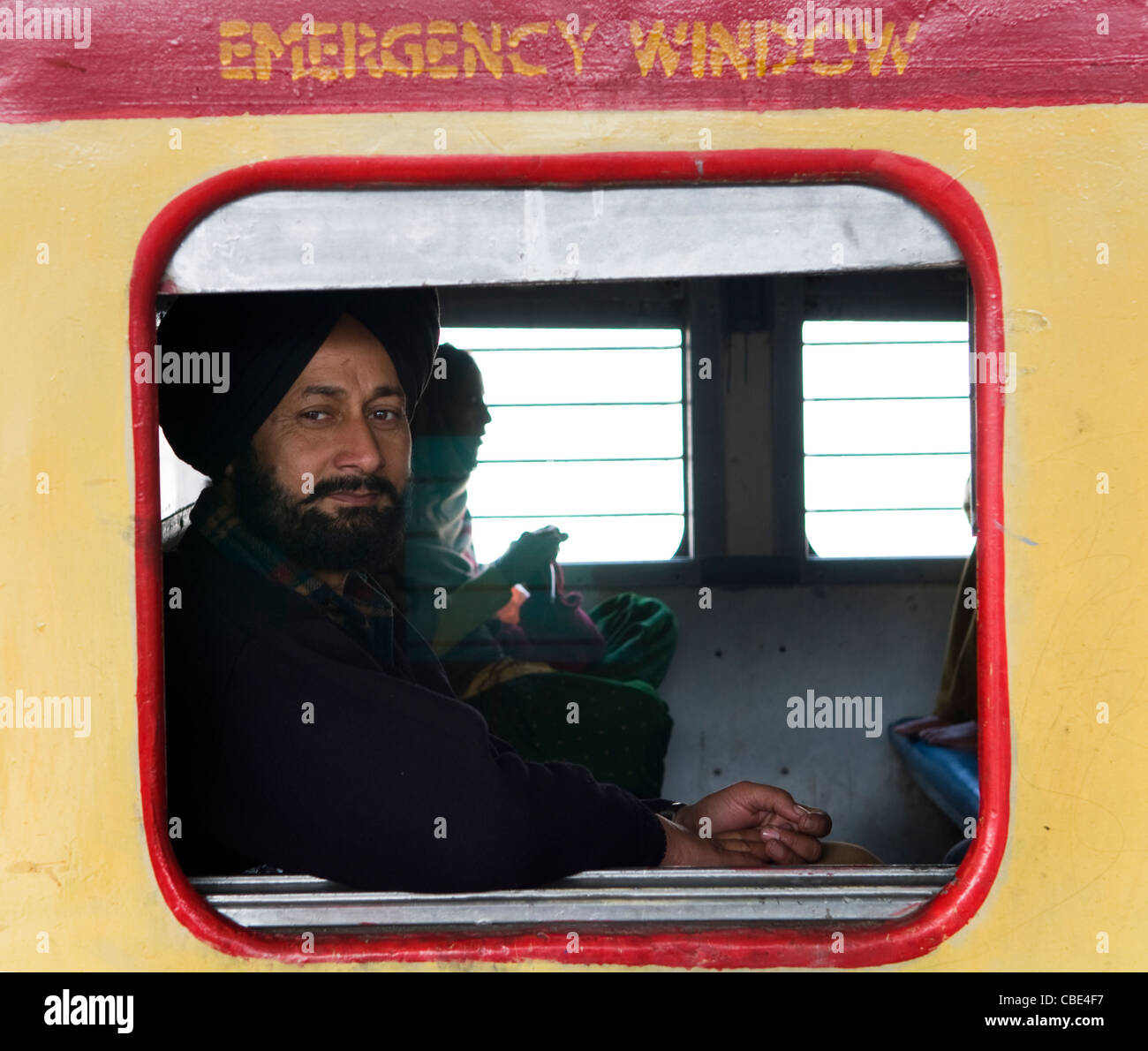 Ein Sikh Mann sitzt in einem indischen Zug. Stockfoto