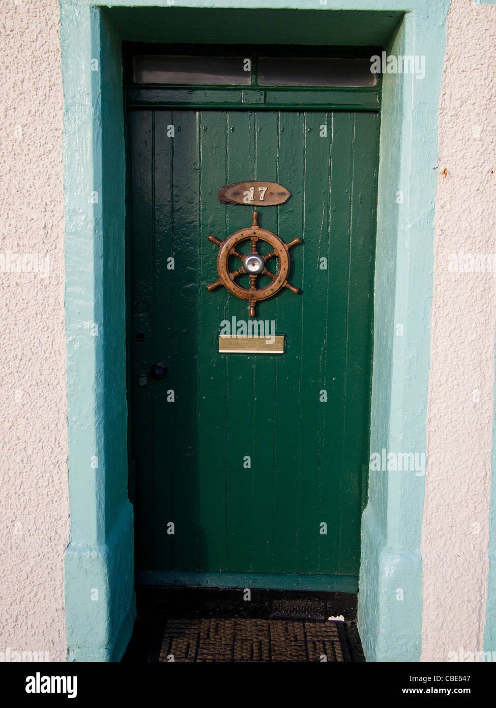 Grüne Tür mit Schiffs-Rad-Ornament Stockfoto