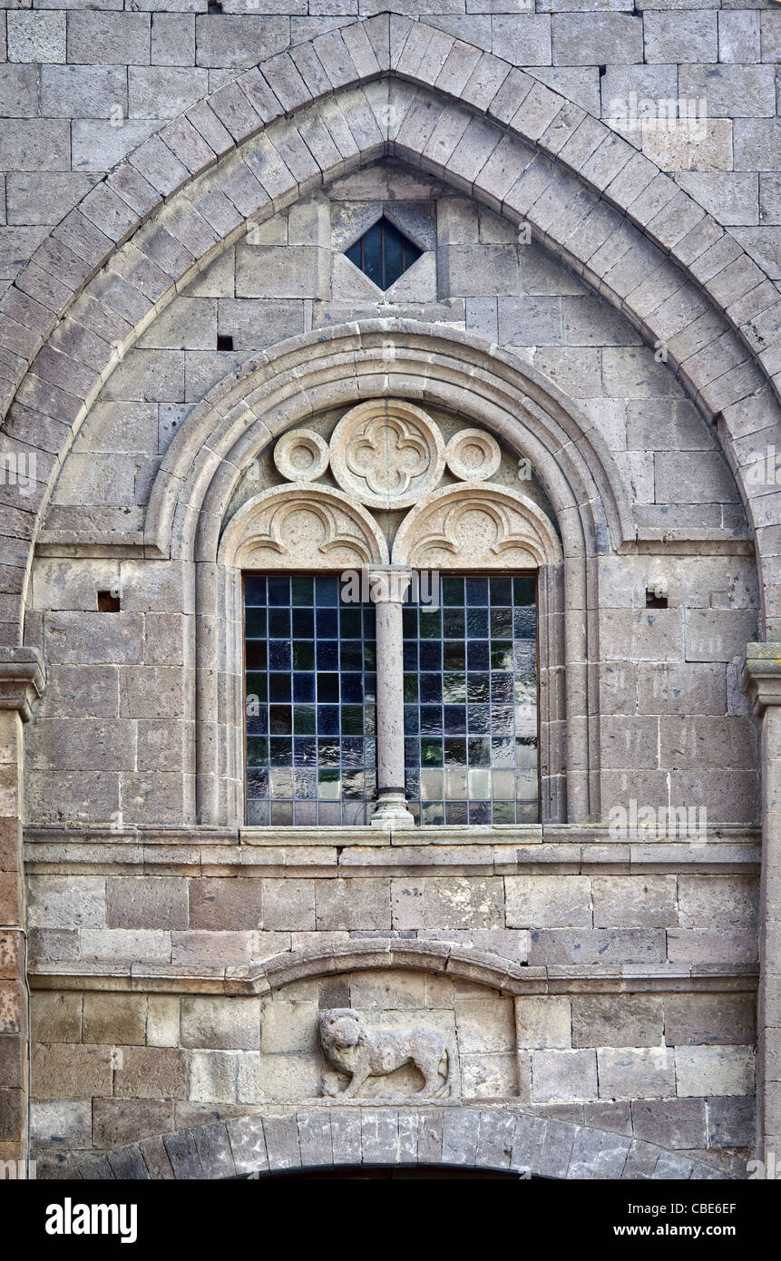 Detail der Fassade mit einem zweibogigen Fenster und der Löwe im Hochrelief, Kirche von San Leonardo in Tuscania, Italien Stockfoto