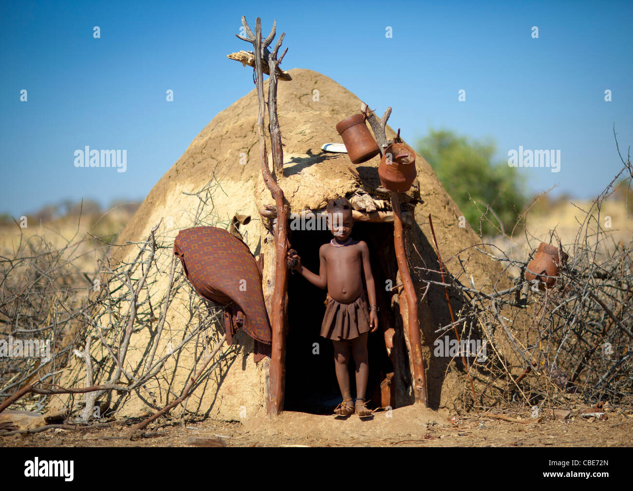 Muhimba Mädchen am Eingang von ihrer Hütte, Dorf Elola, Angola Stockfoto