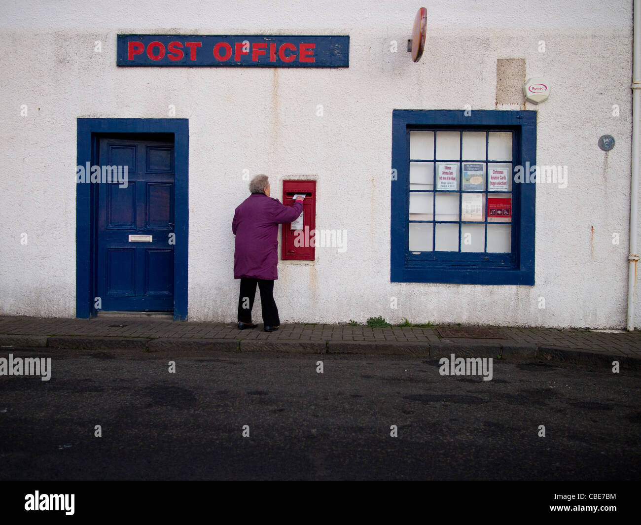 Frau einen Brief im Briefkasten, St Monans, Fife buchen Stockfoto