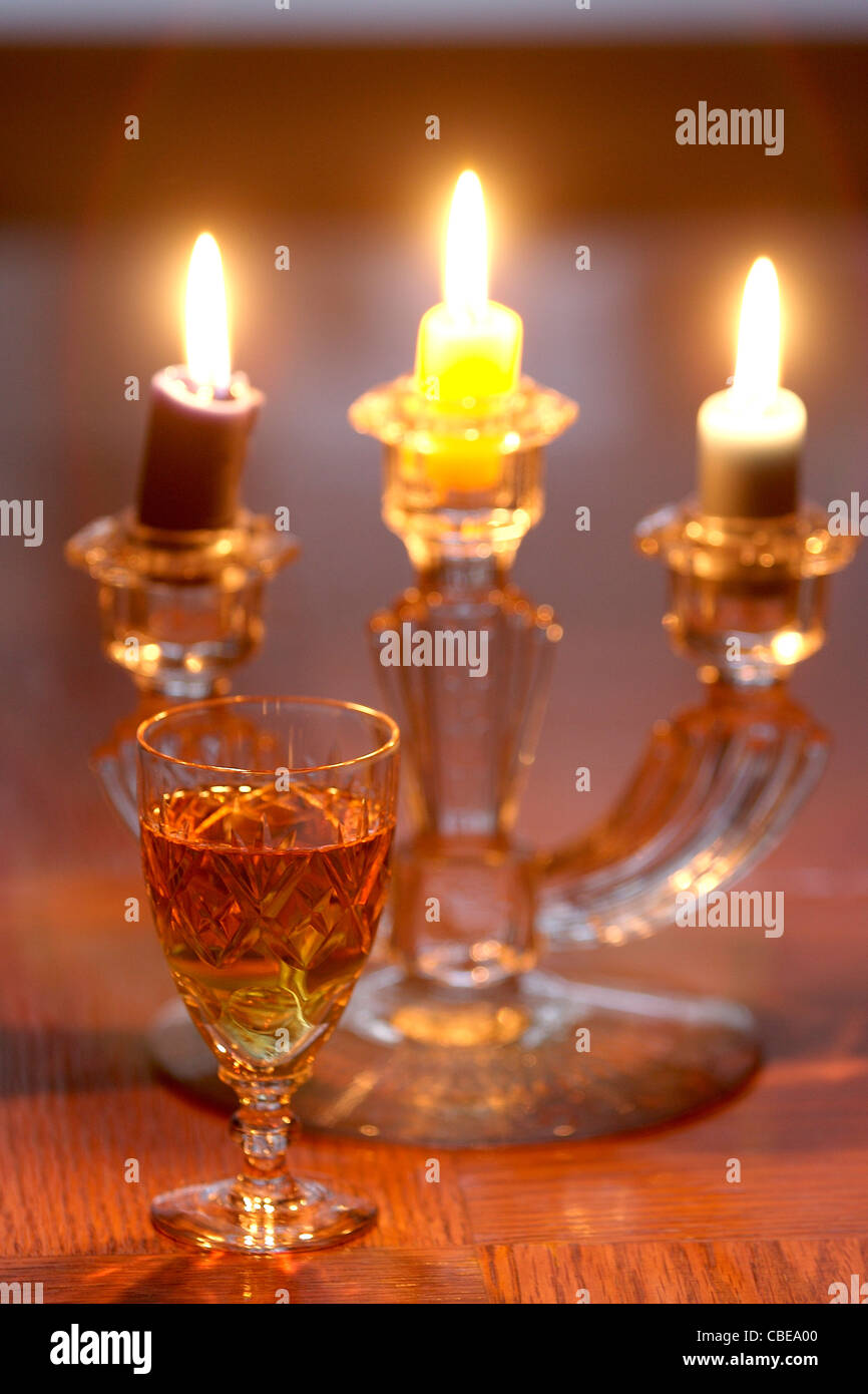 Kristallglas mit Napoleon Cognac VSOP und Kerzen beleuchtet in der backgroung Stockfoto