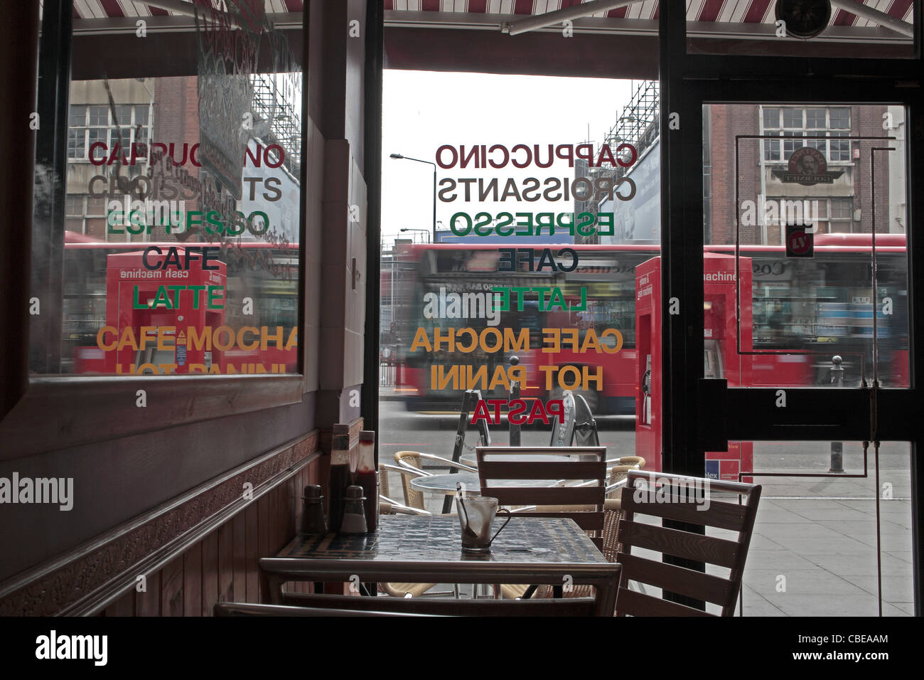 Londoner East End Cafe innere Blick aus Fenster zur Straße zeigt Bus in Bewegung, leere Kaffeetasse auf Tisch Stockfoto