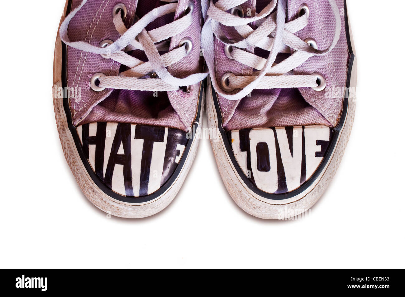 Jugendliche, die mit den Worten Converse Schuhe angepasst Hass und Liebe auf weißem Hintergrund Stockfoto