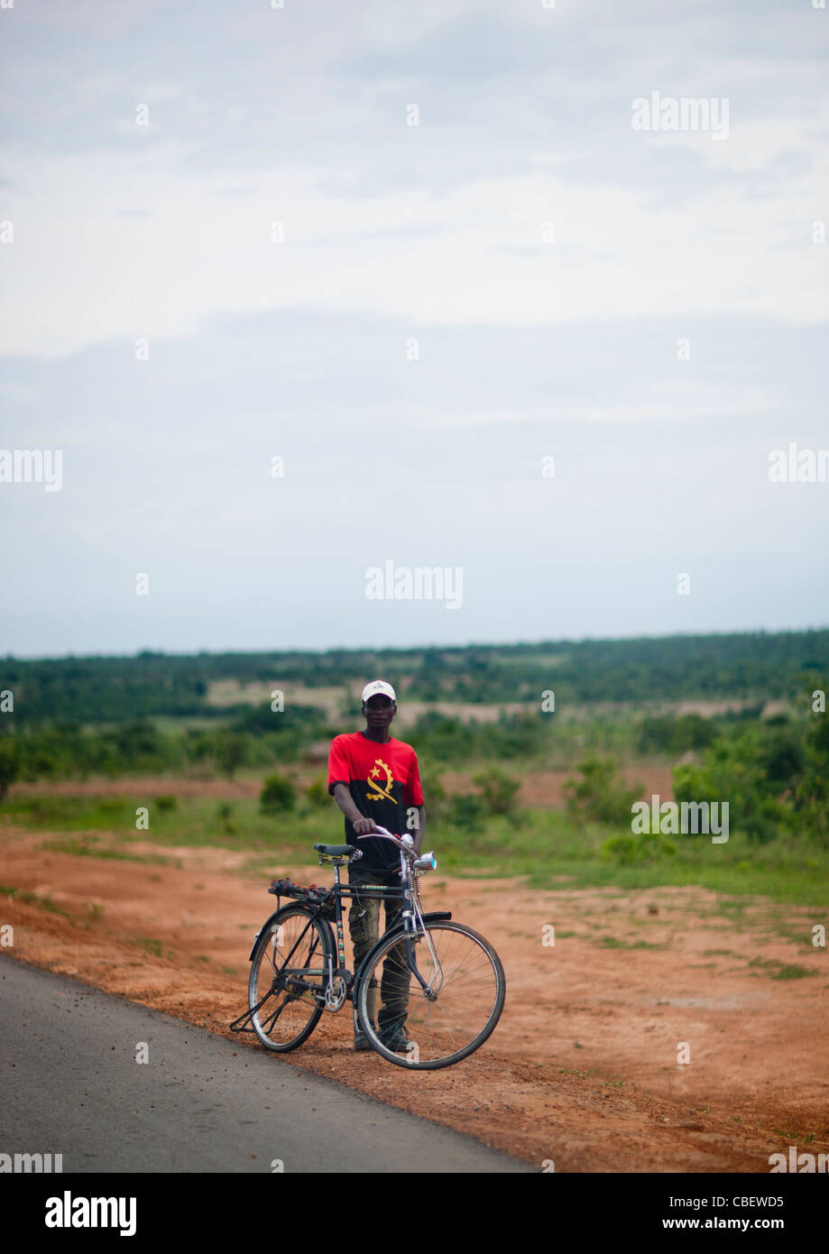 Mann mit einem Fahrrad trägt ein T-Shirt mit den Farben der Nationalflagge, Angola Stockfoto