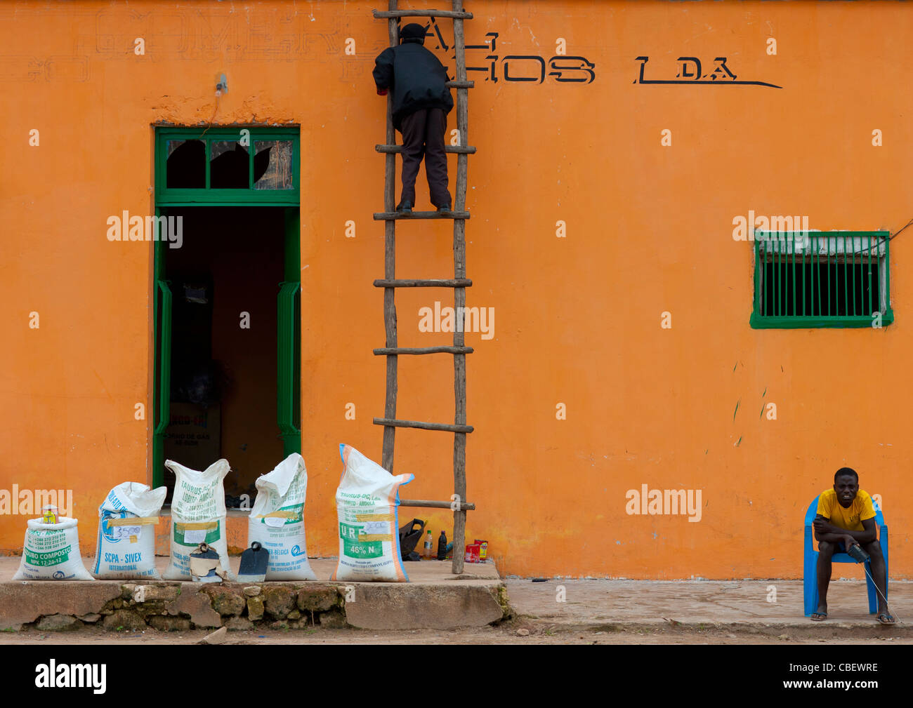 Die Fassade der sein Geschäft auf einer Leiter, Angola Bild Mann Stockfoto