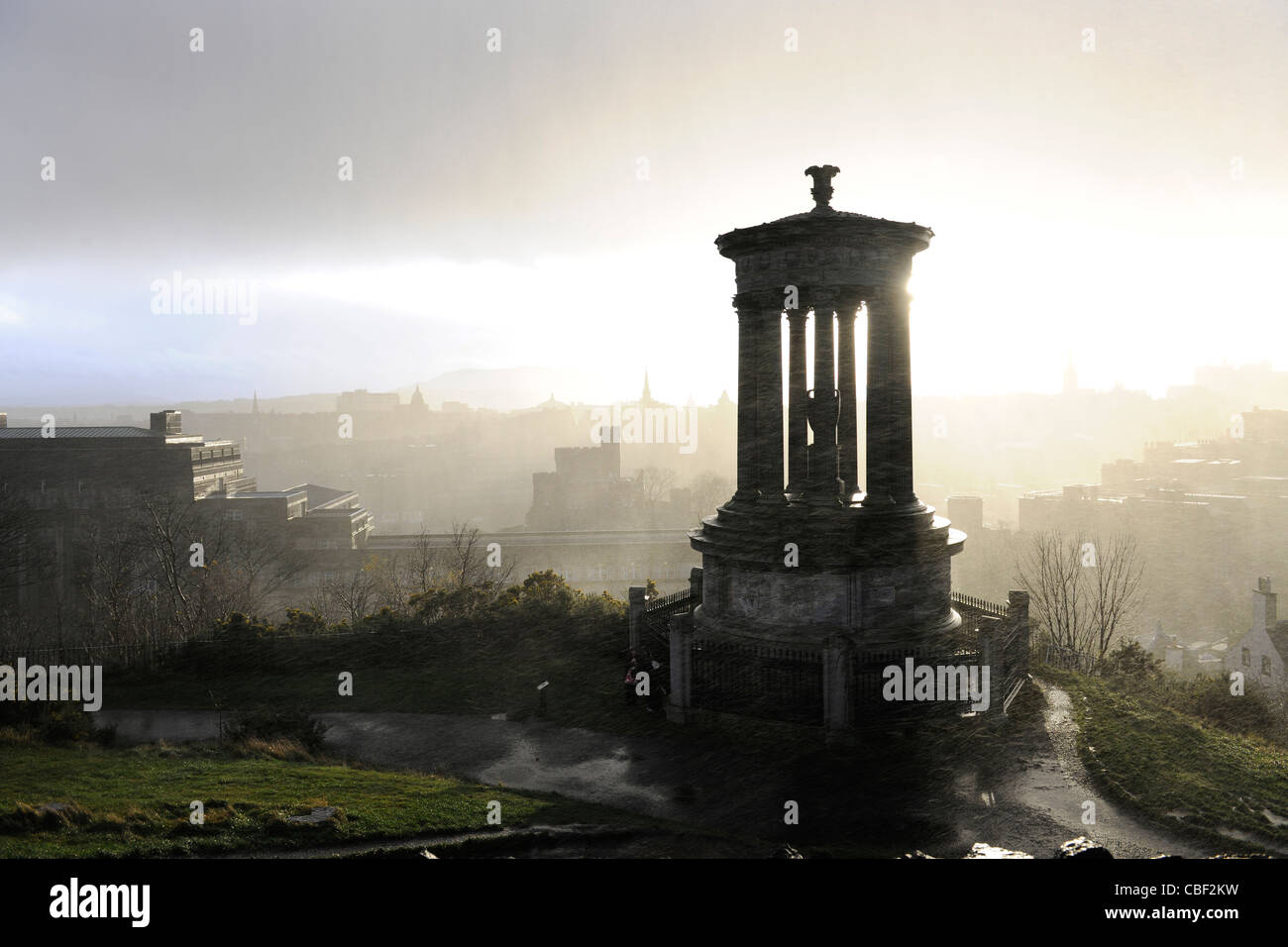 Blick vom Calton Hill mit Dugald Stewart Monument im Vordergrund. Mit Sonne Regen und Graupel zur gleichen Zeit. Stockfoto