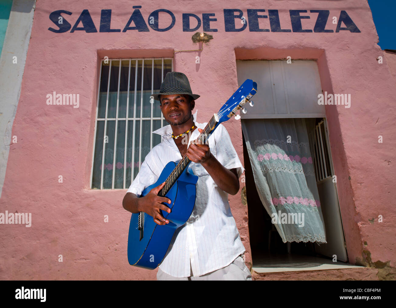 Mann mit Hut, die Gitarre vor einem Beauty-Salon, Angola Stockfoto