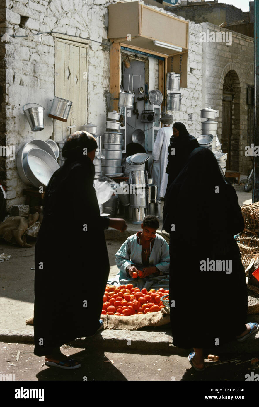 Weibliche Käufer in Burkas und Tomaten Lieferanten, Basar, Assuan, Ägypten Stockfoto