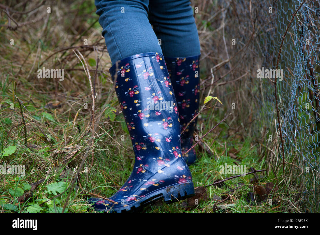 Eine Frau trägt Gummistiefel in Formby Stockfoto