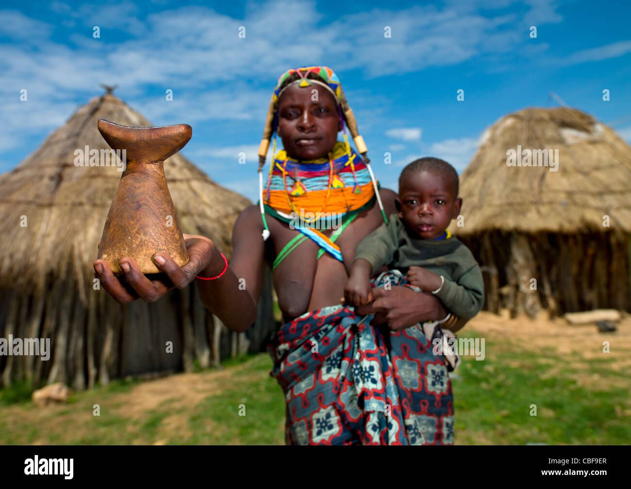 Mwila Frau mit ihrem Sohn auf dem Arm zeigt eine Kopfstütze, Angola Stockfoto