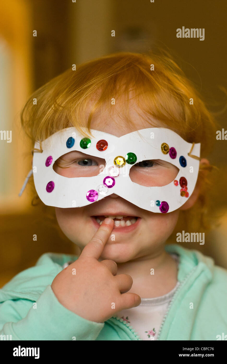 Kinder spielen - kleines Mädchen mit einer hausgemachten Maske Stockfoto