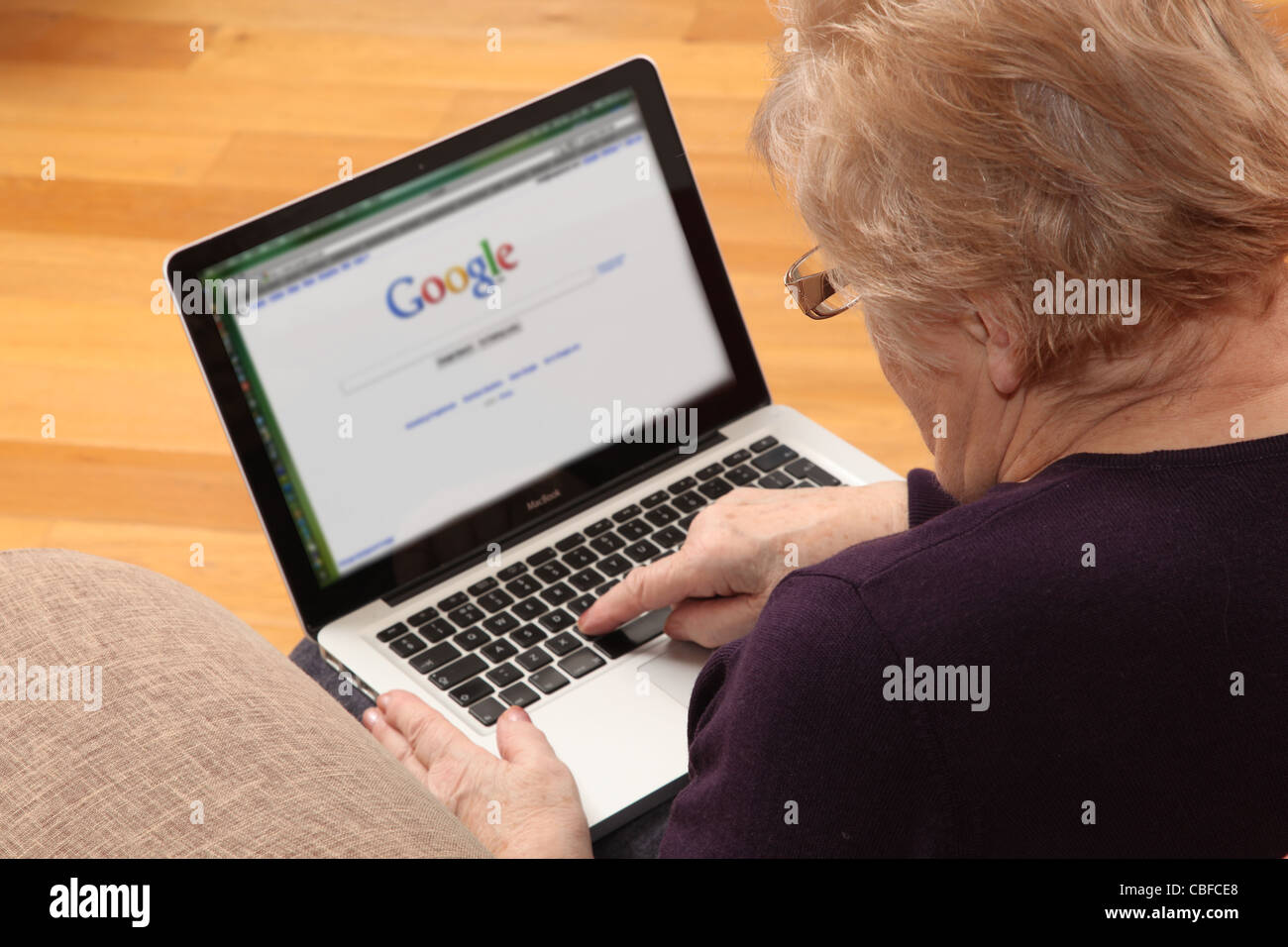 Reife Frau mit ihrem Laptop über das Internet mit Suchmaschine auf dem Bildschirm. Stockfoto