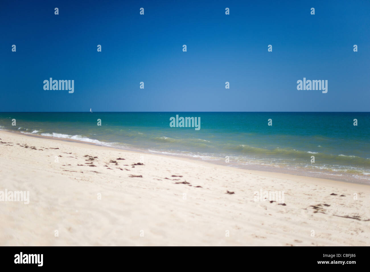 Segelboot zu sehen in der Ferne vom Strand in Vale Do Lobo, Algarve, Portugal Stockfoto