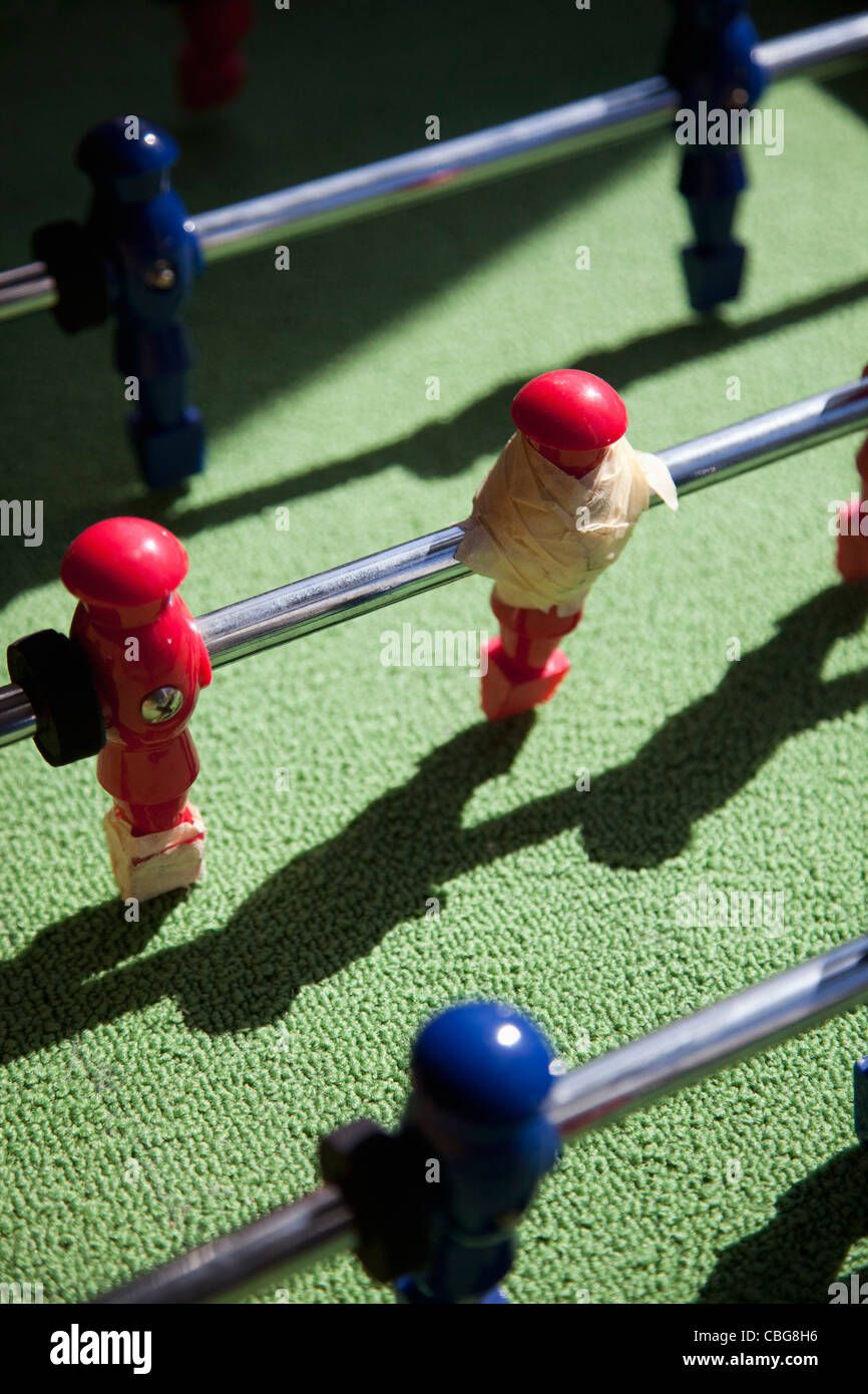 Ein Tischfußball-game-Spieler mit Klebeband repariert Stockfoto