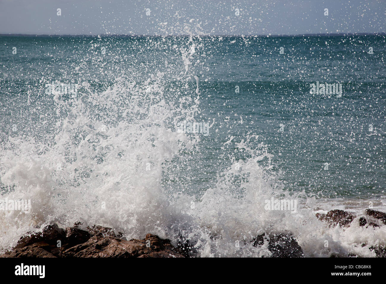 Detail einer Welle auf Felsen spritzt Stockfoto