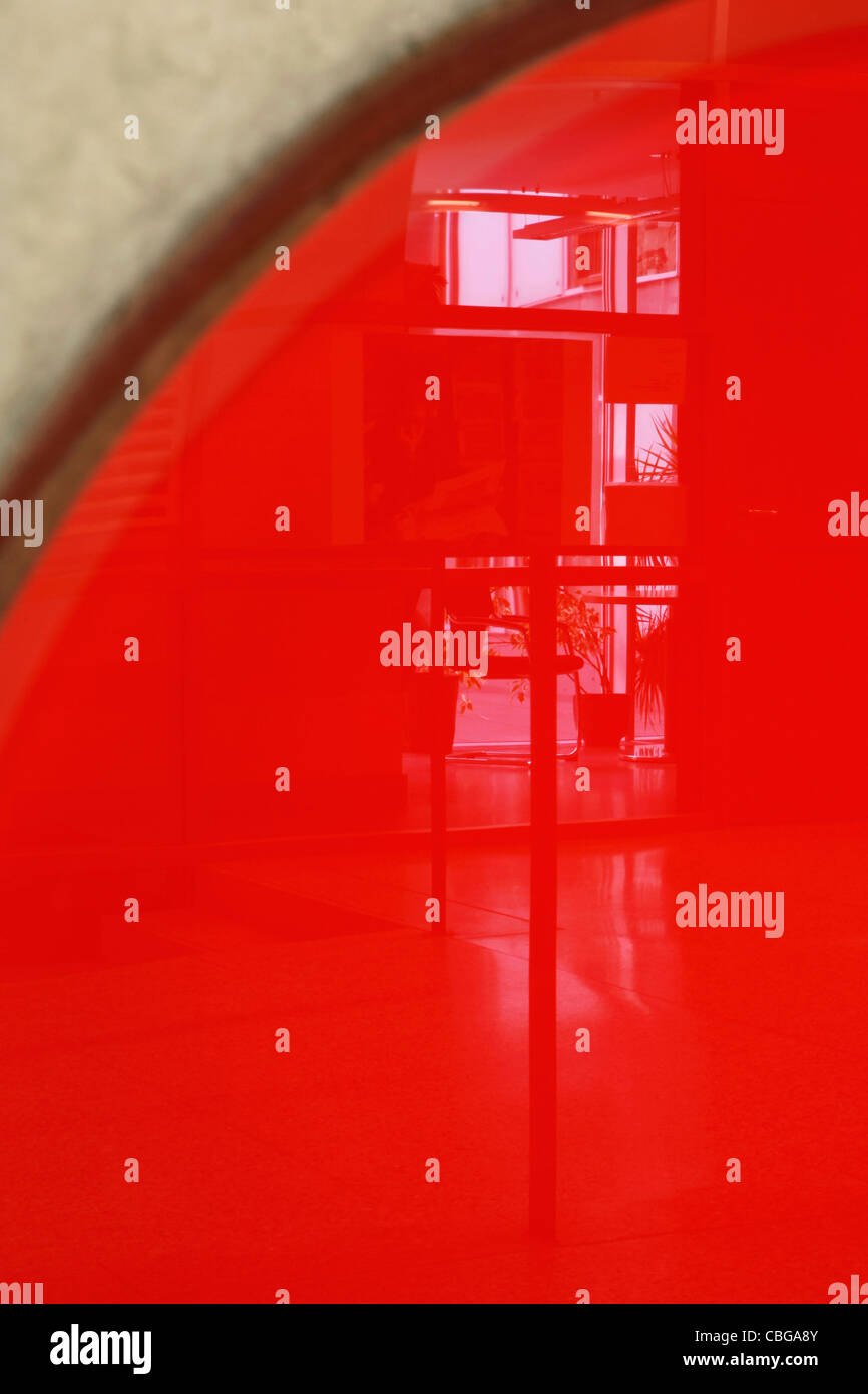 Reflexion von Windows gegen helles rotes Objekt auf Wand Stockfoto